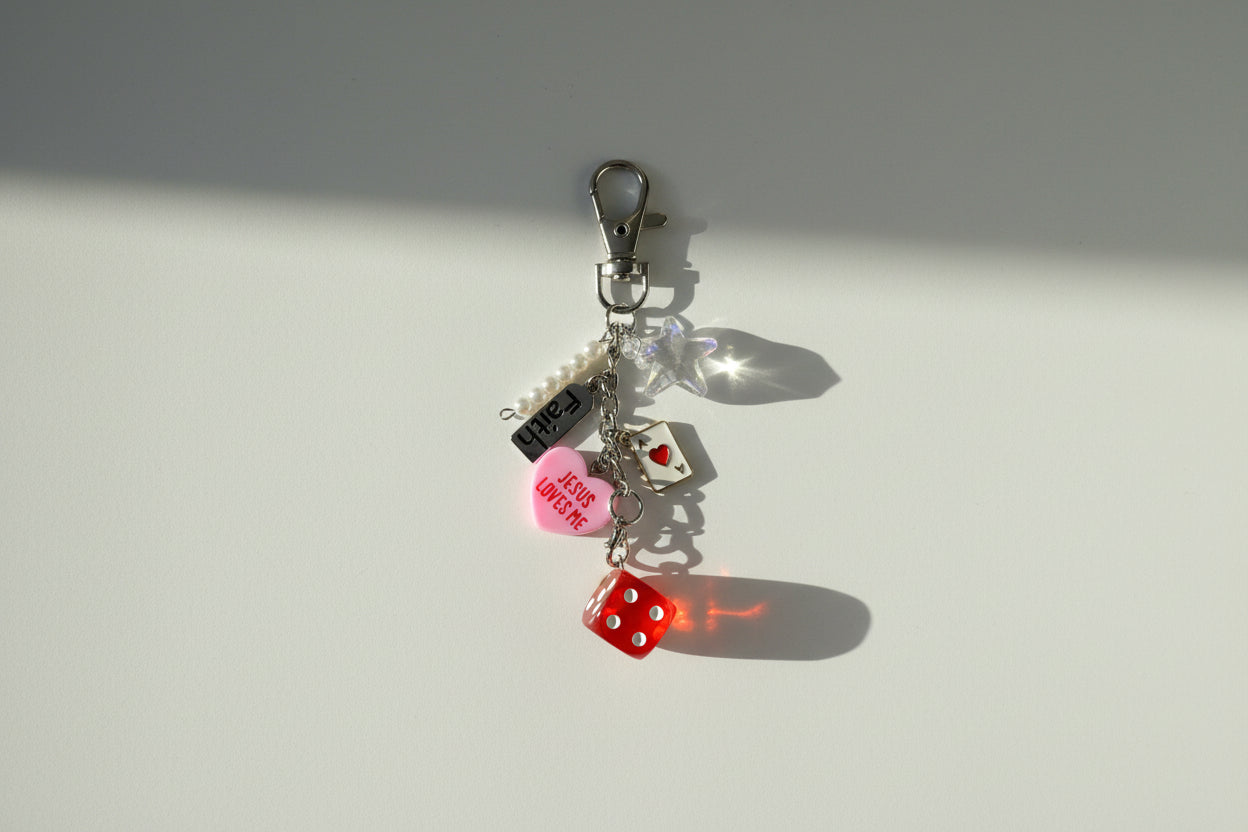 Keychain with heart-shaped tag and red object on a textured surface